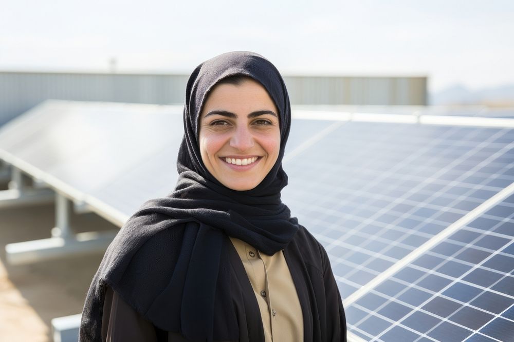 A solar Iranian woman worker smiles in front of solar panels scarf happy environmentalist.