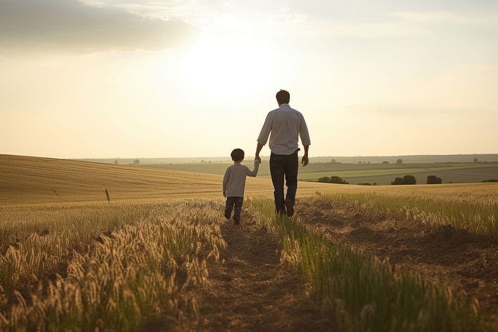 Father holds his son walking field landscape.