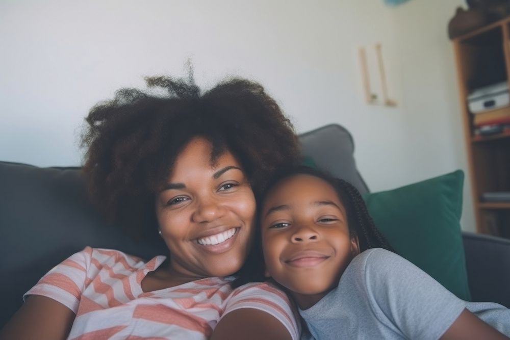 Daily life of black mom and daughter wacthing TV in the room portrait family happy.