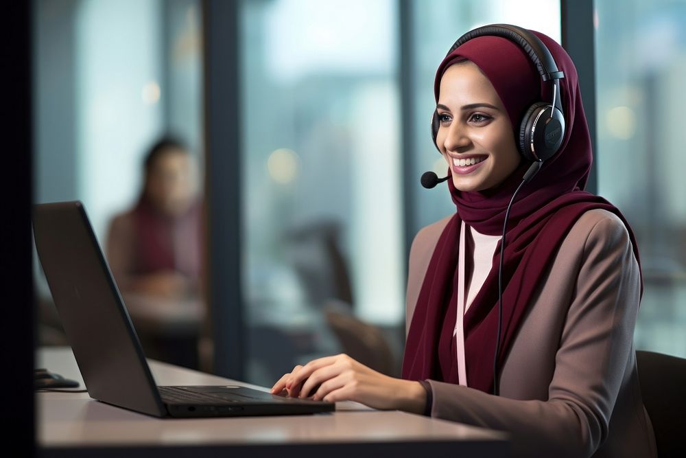 Qatari woman working at call center laptop headphones computer.