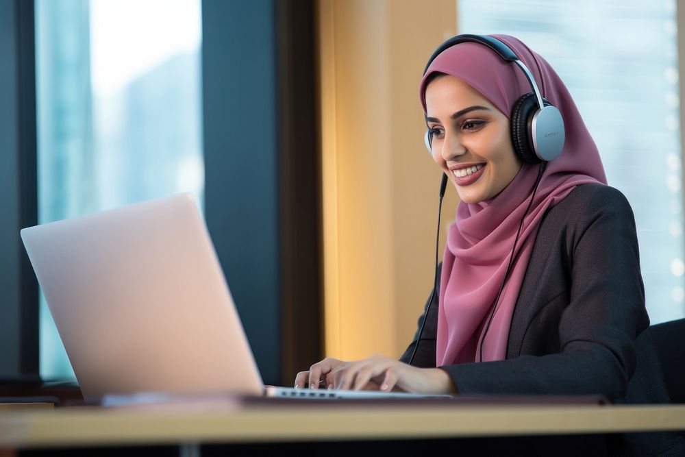 Qatari woman working at call center laptop headphones computer.