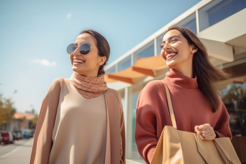 Young adult Iranian women shopping together laughing happy sky.