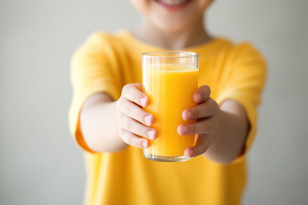 Kid hands in holding orange juice in glass smiling drink refreshment. 
