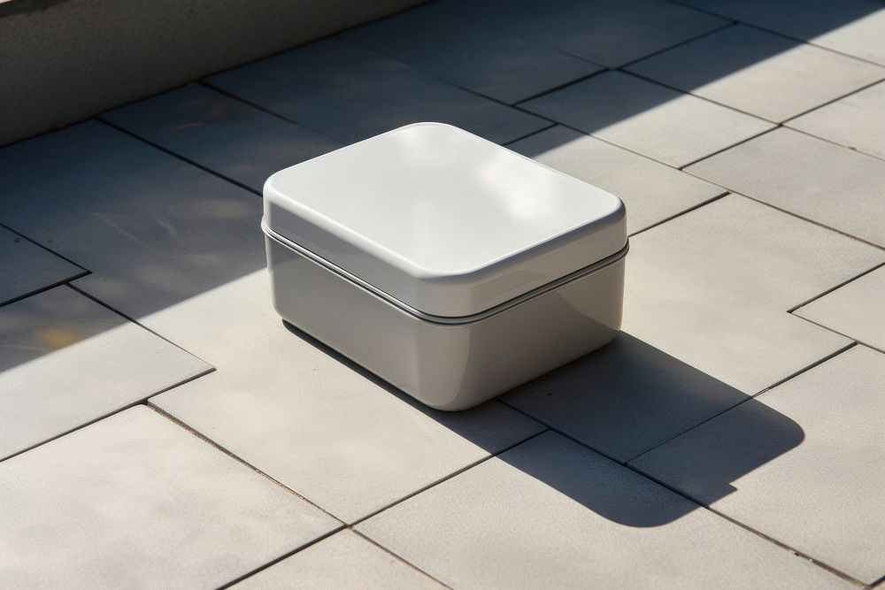 A stainless steel lunch box silicone lid and white silicone strap  architecture porcelain furniture.