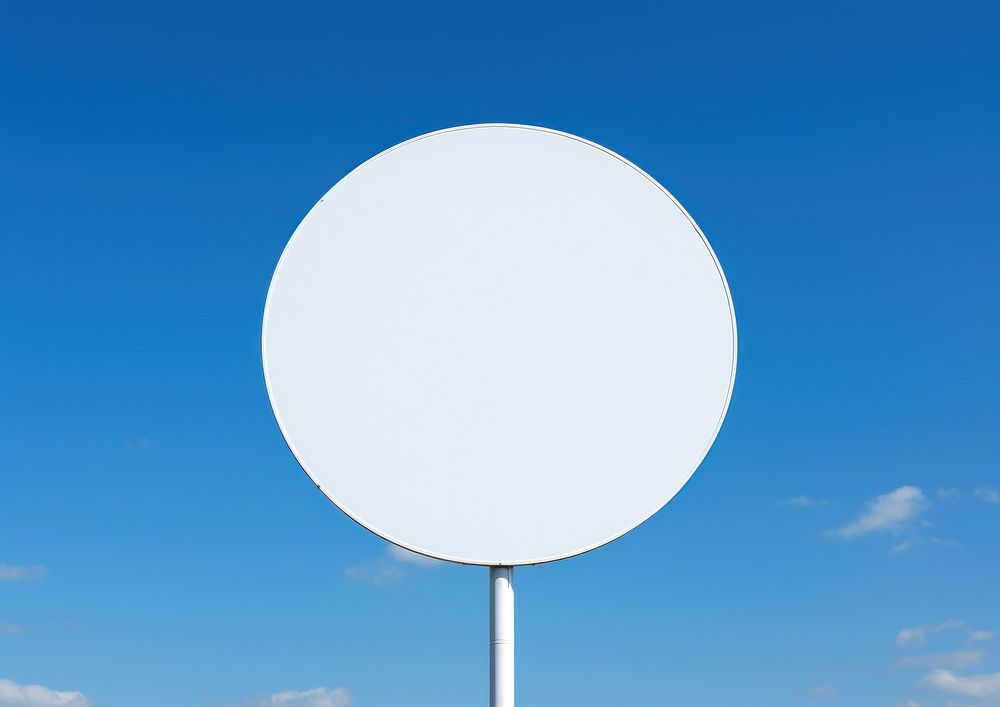 Blank white round traffic sign attached metal pole sky outdoors blue.