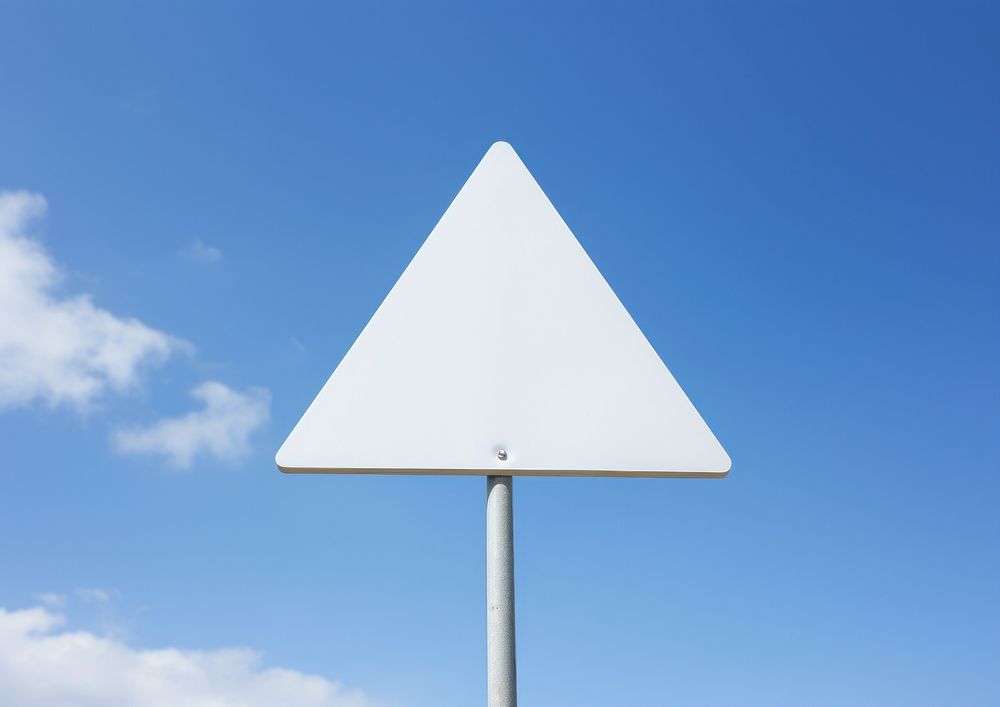 Blank white triangle warning sign attached metal pole sky outdoors symbol.