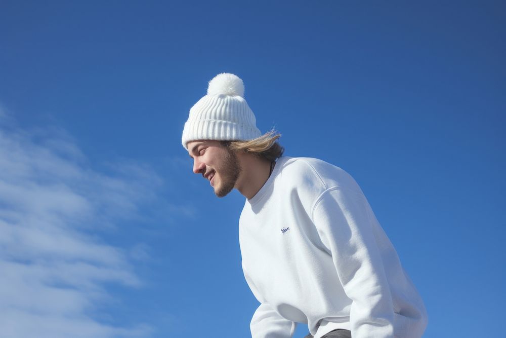 A adult man wearing white short matching flannel beanie outdoors nature blue.