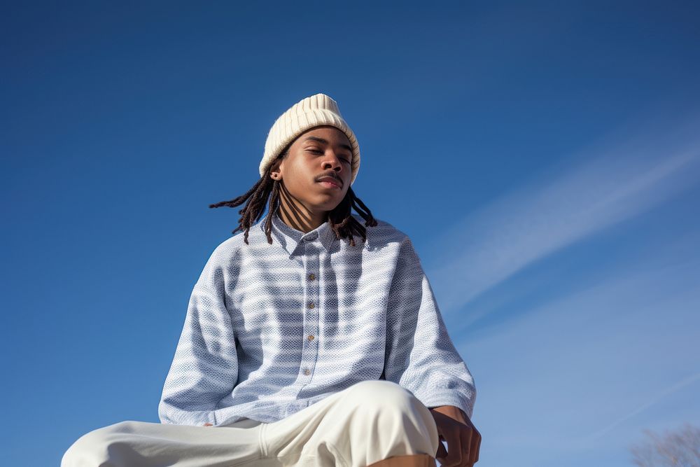 A black young man wearing white short matching flannel beanie sitting adult blue.