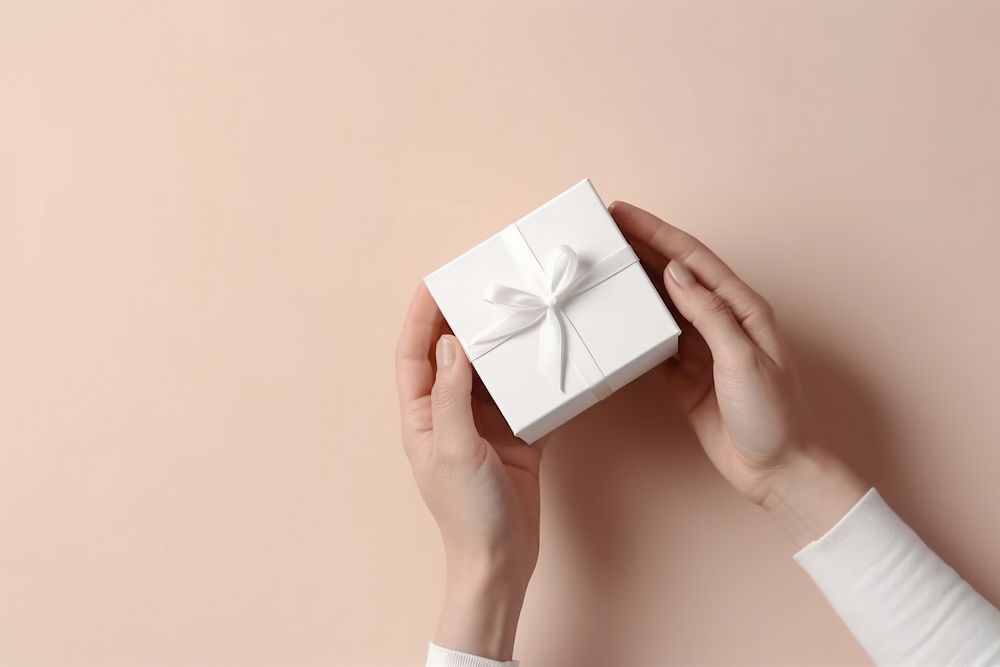 Gift box holding paper hand.