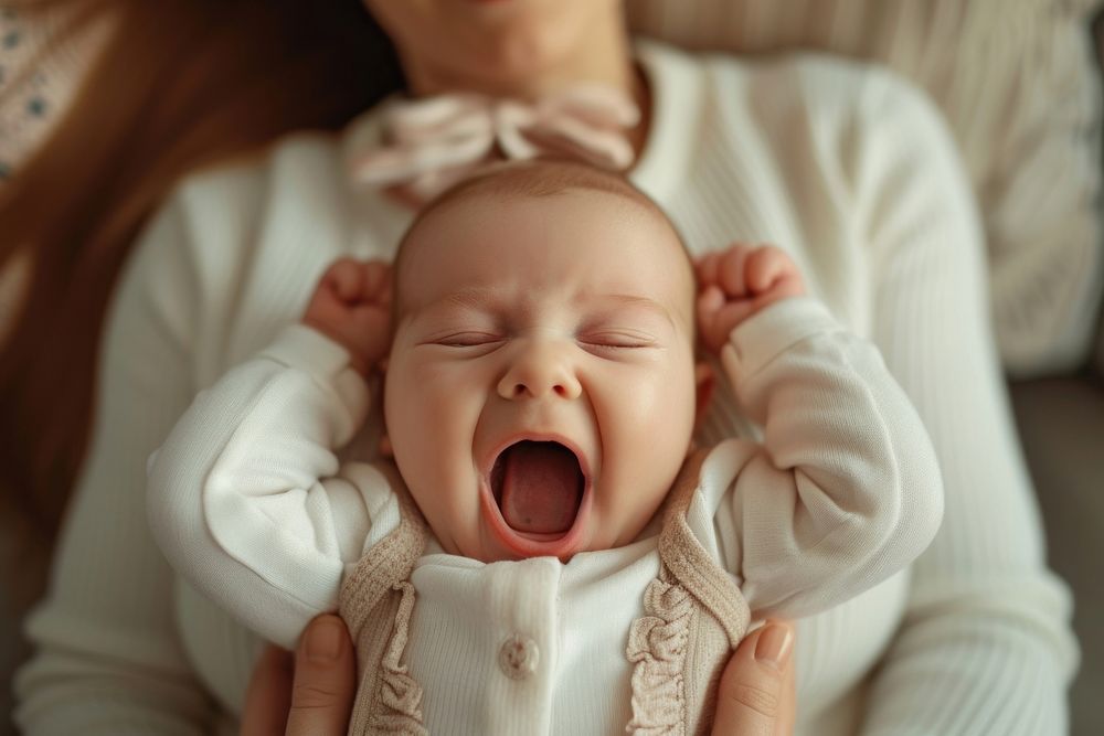 Baby girl making faces lying newborn yawning cute.