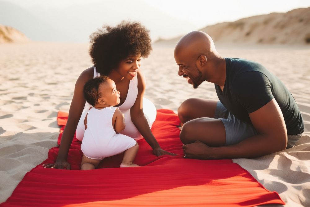 Black family on a beach mat with a baby in towel photography portrait adult.