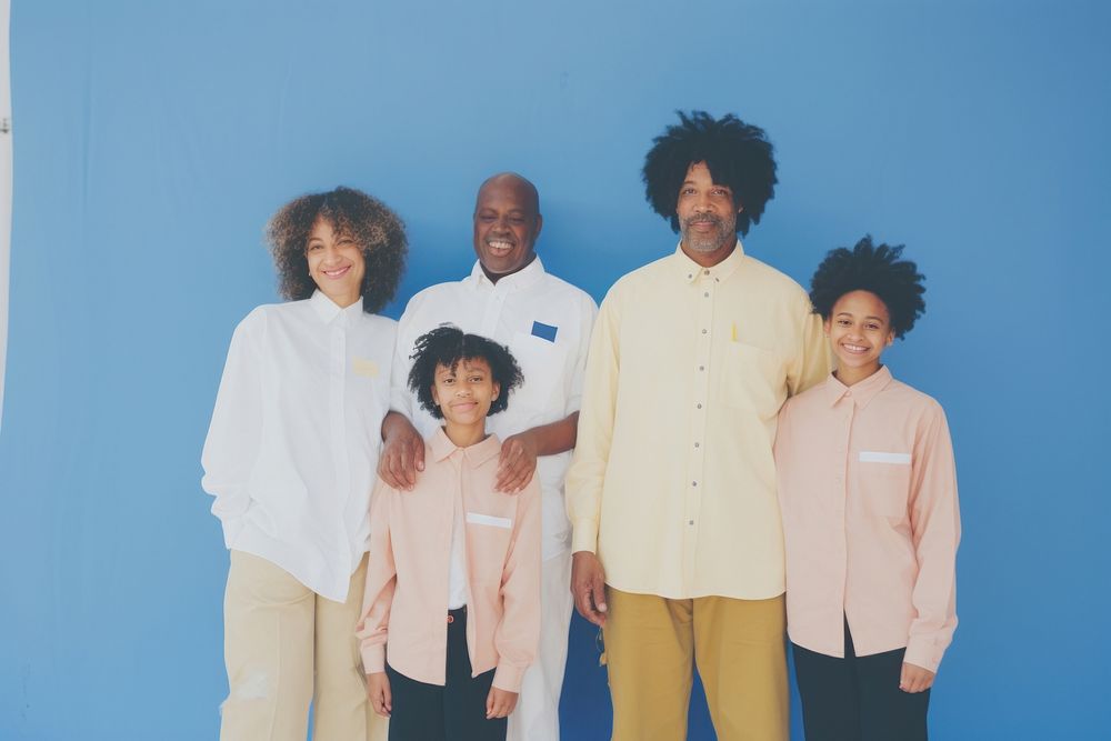Black family wearing blank white shirt poses at studio for portrait pictures parent adult togetherness.