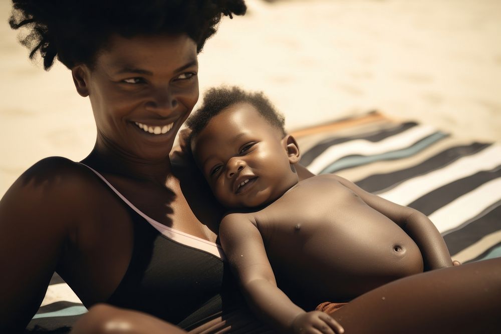 Black mom on a beach mat with a baby in tow photography portrait swimwear.