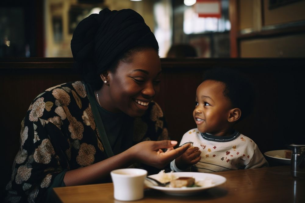 Black mom feeding son chocolate cake at a yakuni sushi restaurant portrait adult baby.