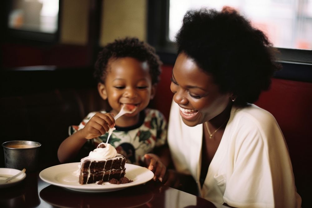 Black mom feeding son chocolate cake at a yakuni sushi restaurant portrait child adult.