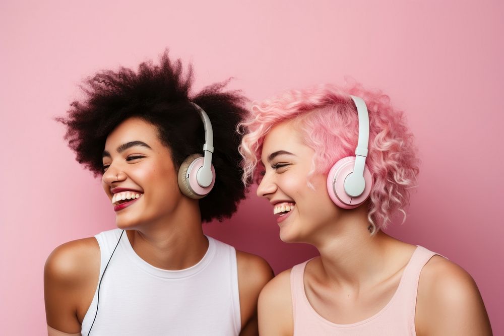 Two friends headphones listening laughing.