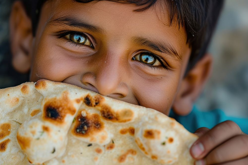 Indian kid eating food bread naan.