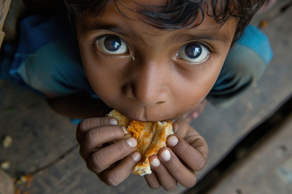 Indian kid eating food biting child.