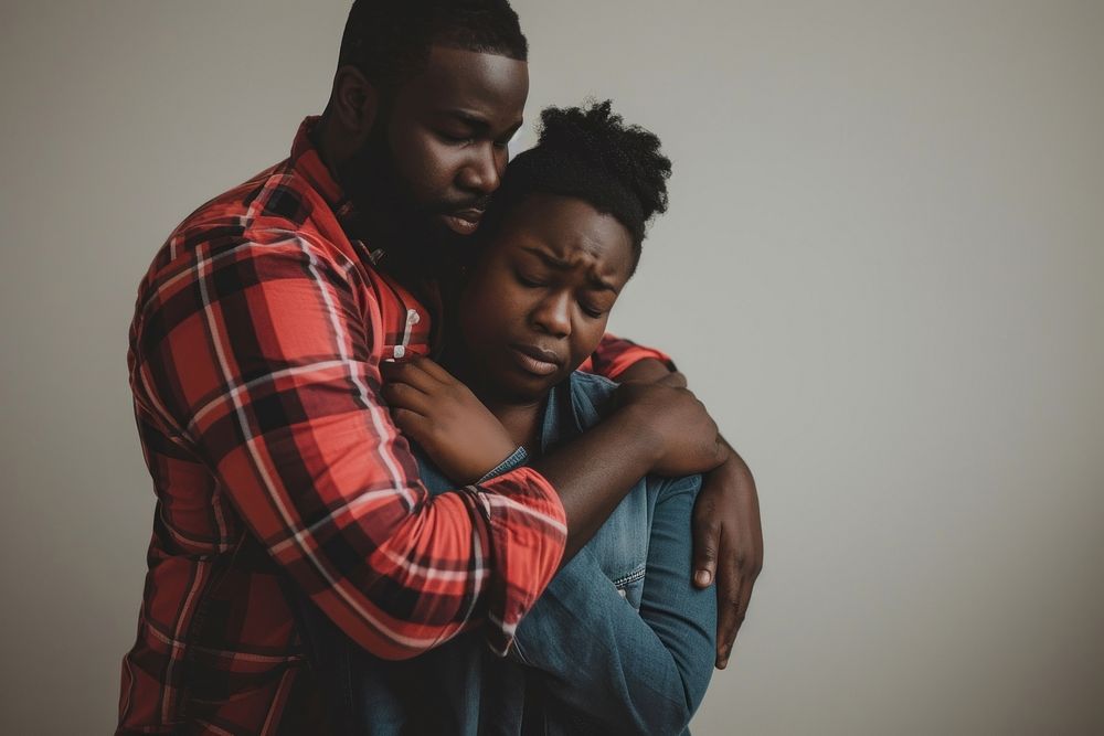 Black couple portrait hugging adult.