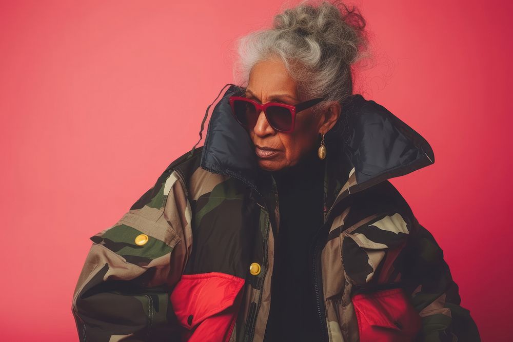 Cool senior black woman with fashionable clothing style portrait on colored background glasses jacket adult.