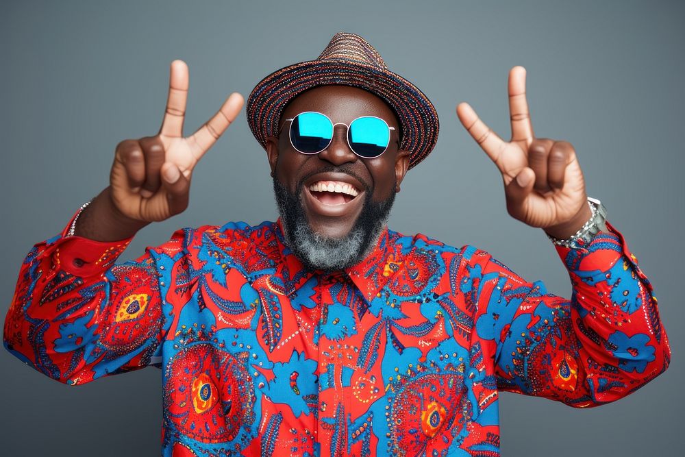 Cool senior black man with fashionable clothing style portrait on colored background sunglasses laughing smile.