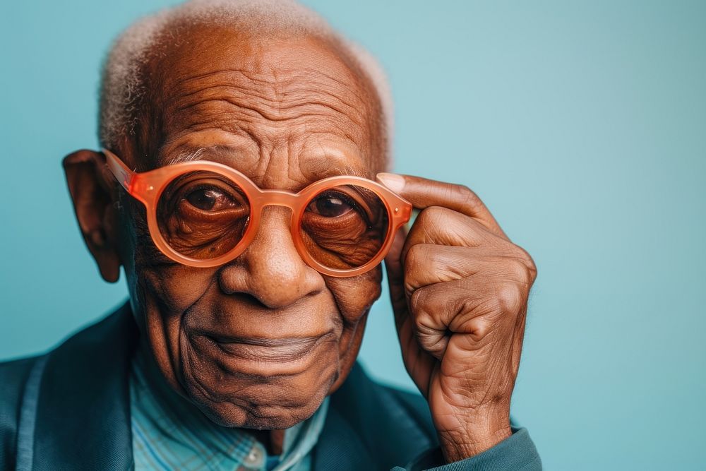 Cool senior black man with fashionable clothing style portrait on colored background glasses adult male.