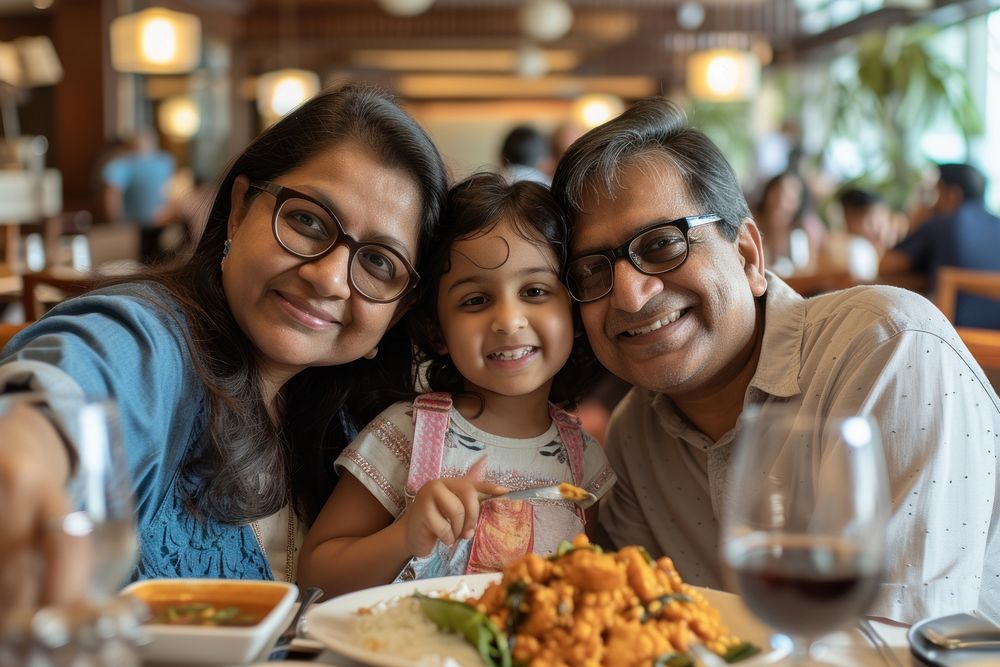 Indian family eating restaurant food portrait.