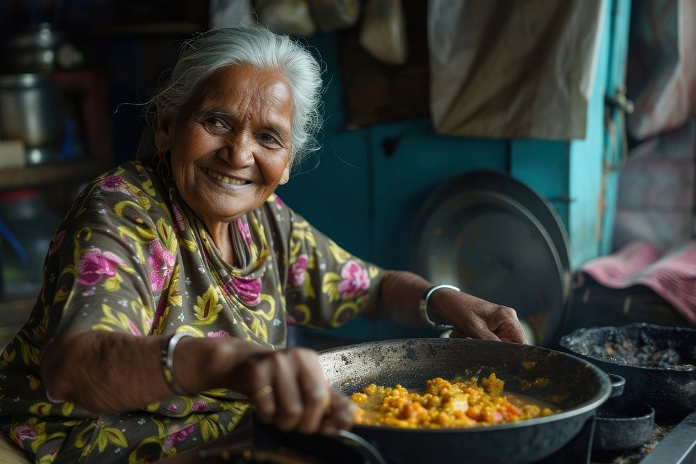 Indian grandfather cooking food smiling adult.