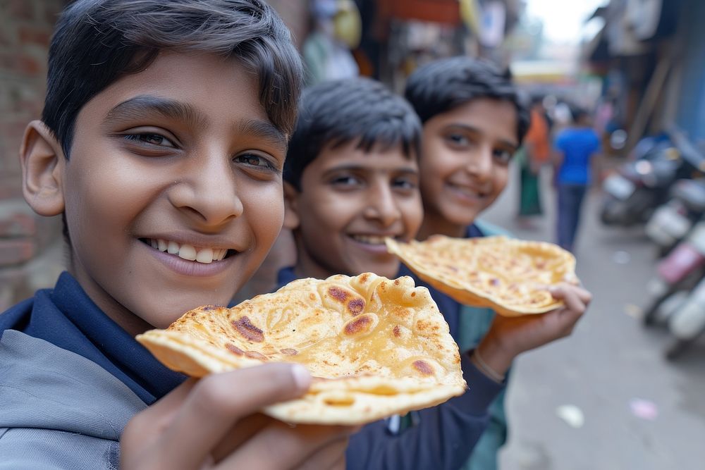 Indian boys eating food smiling bread.