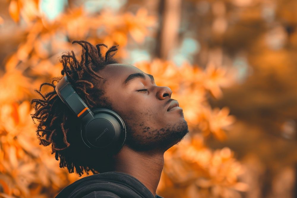 Happy young black man enjoying music listening through wireless headphones on footpath headset adult electronics.