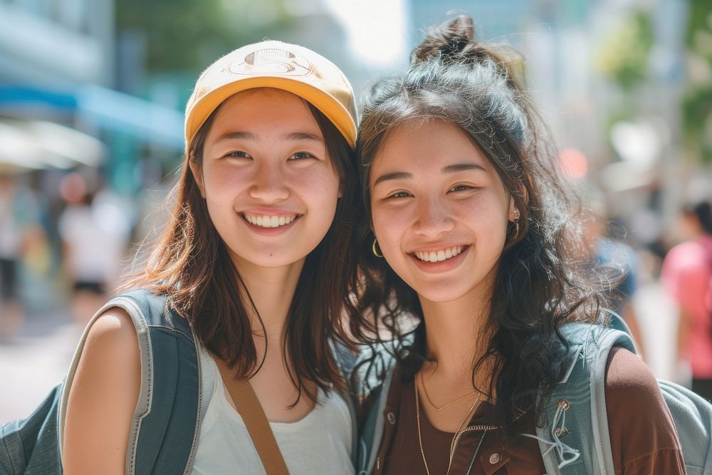 Two asian mixed race woman laughing portrait outdoors.