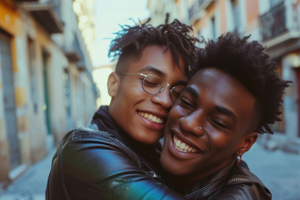 Two happy beautiful young African American gay hugging laughing adult.
