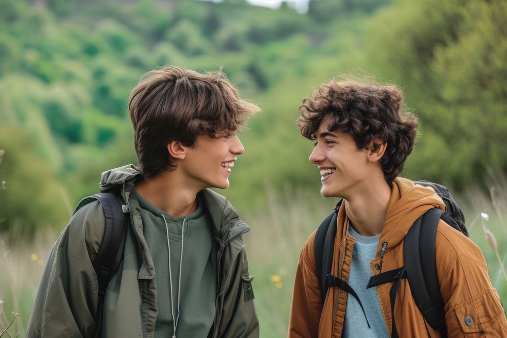 Mixed race teen men outdoors backpack smiling.