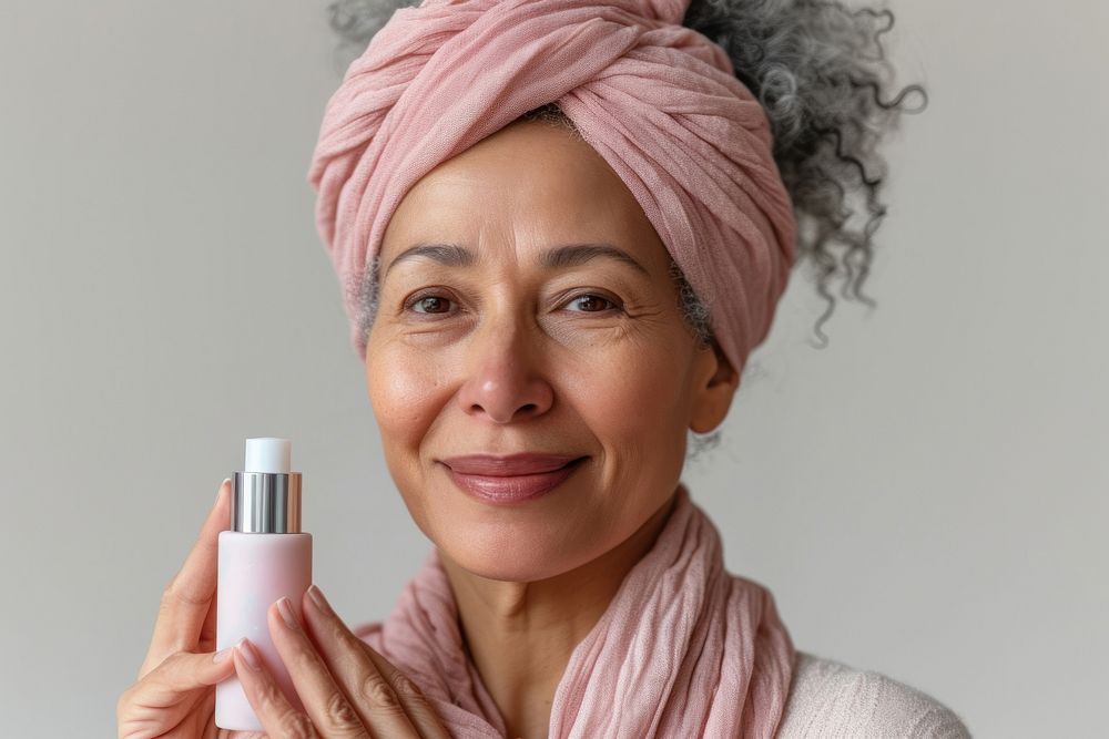 Multiracial senior woman holding a skincare bottle cosmetics scarf adult.