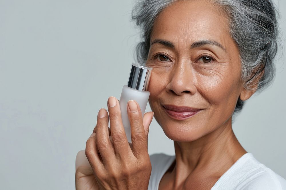Multiracial senior woman holding a skincare bottle cosmetics photo photography.