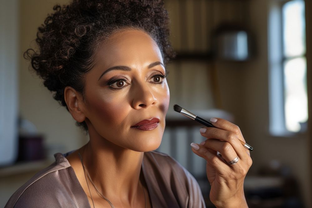 Middle aged multiracial woman doing her makeup fashion accessories hairstyle.