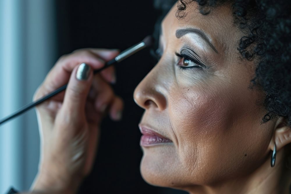 Middle aged multiracial woman doing her makeup fashion adult hairstyle.
