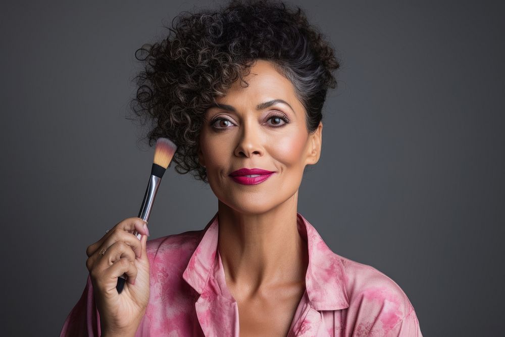 Middle aged multiracial woman doing her makeup fashion individuality hairstyle.