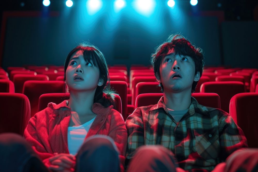 Japanese couple watching horror movie theater adult togetherness.