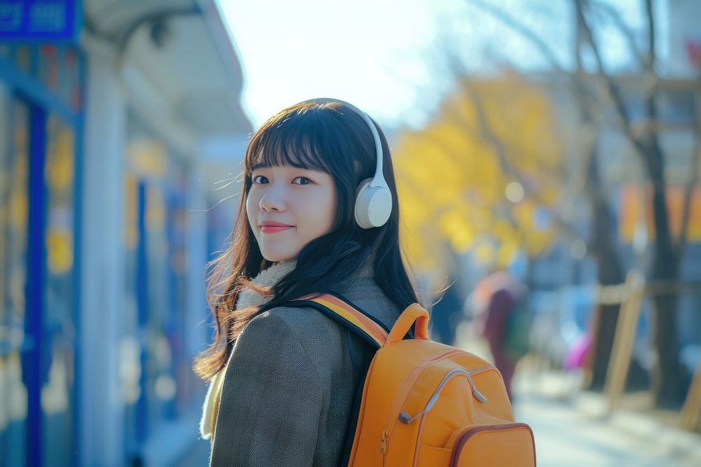 Korean student listening music architecture backpacking headphones.
