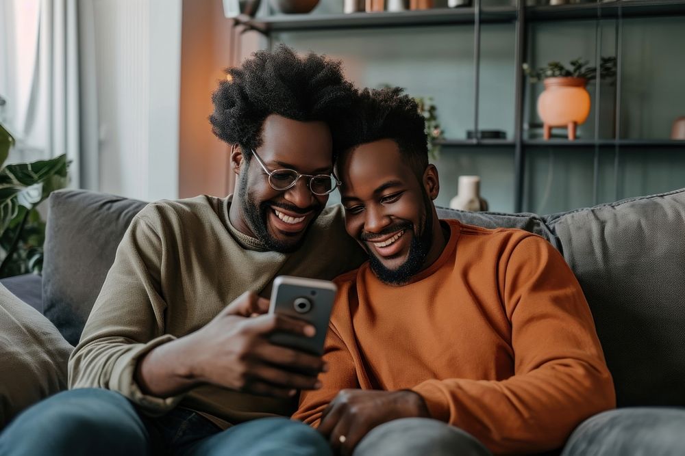 African American Gay couple sitting adult sofa.