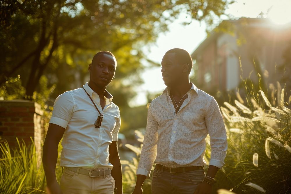 African American gay couple walking in residential neighborhood adult plant togetherness.