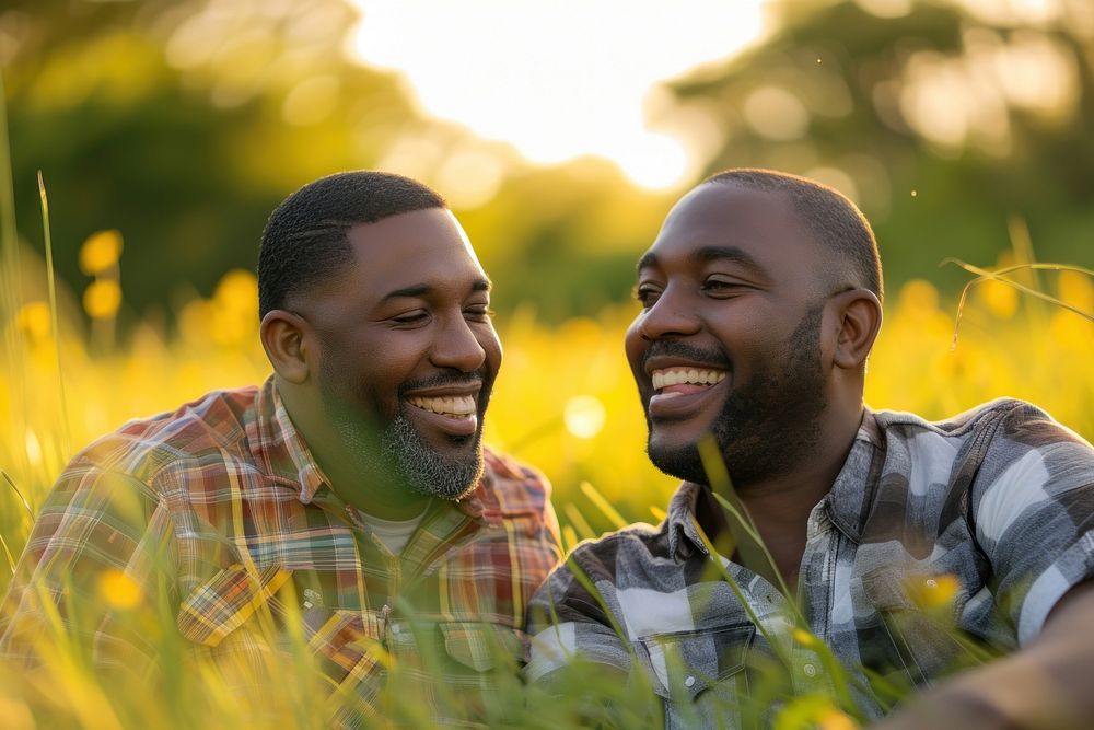 African American Happy Gay couple relaxing in the grass laughing outdoors smile.