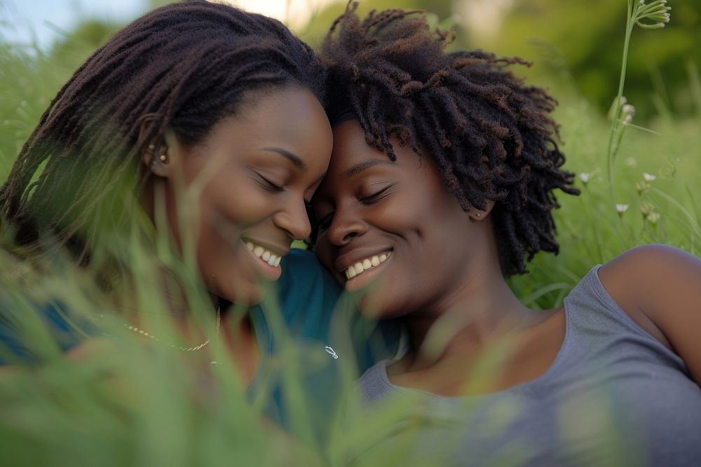 African American Happy lesbian couple relaxing in the grass laughing smile plant.