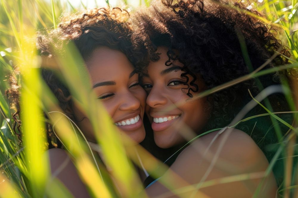 African American Happy lesbian couple relaxing in the grass photography laughing portrait.
