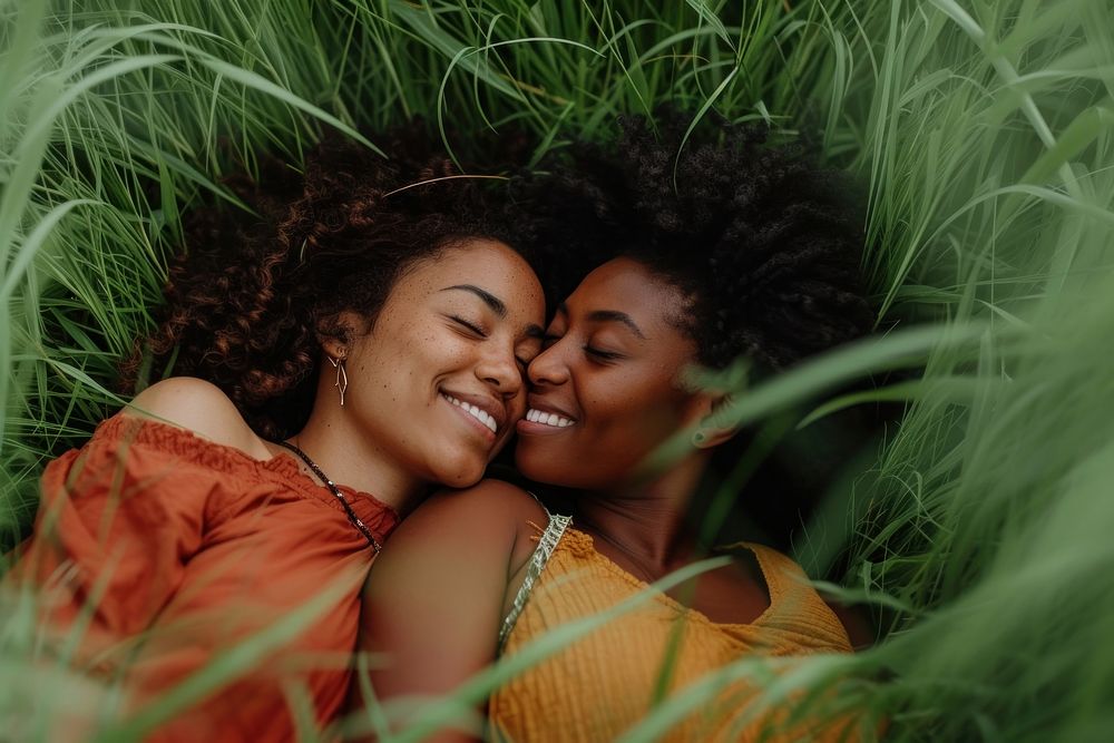 African American Happy lgbtq couple relaxing in the grass photography portrait kissing.