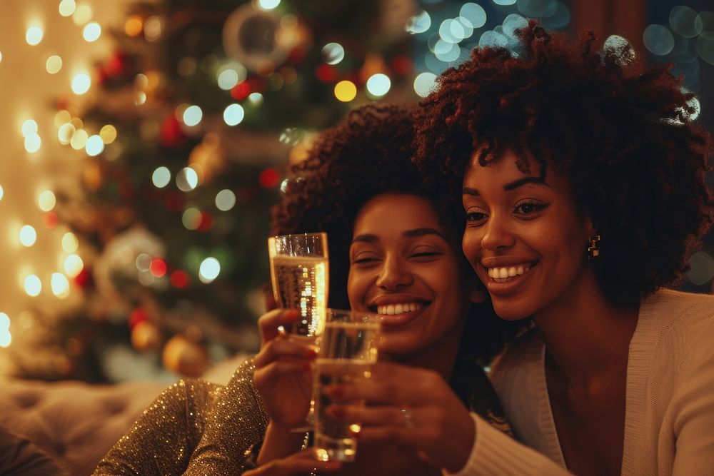 African American lesbian couple drink christmas champagne.