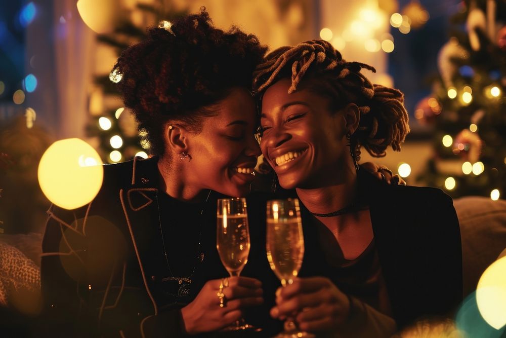 African American lesbian couple christmas champagne laughing.