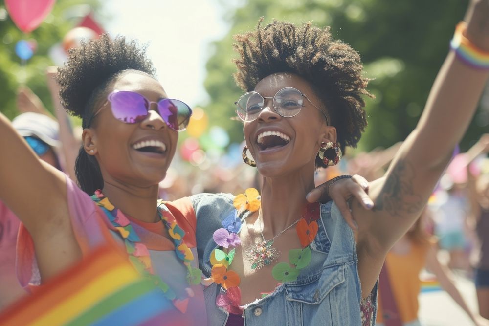 African American lesbian couple celebrating at a parade laughing glasses togetherness.