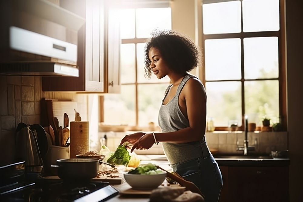 African American woman kitchen cooking food.